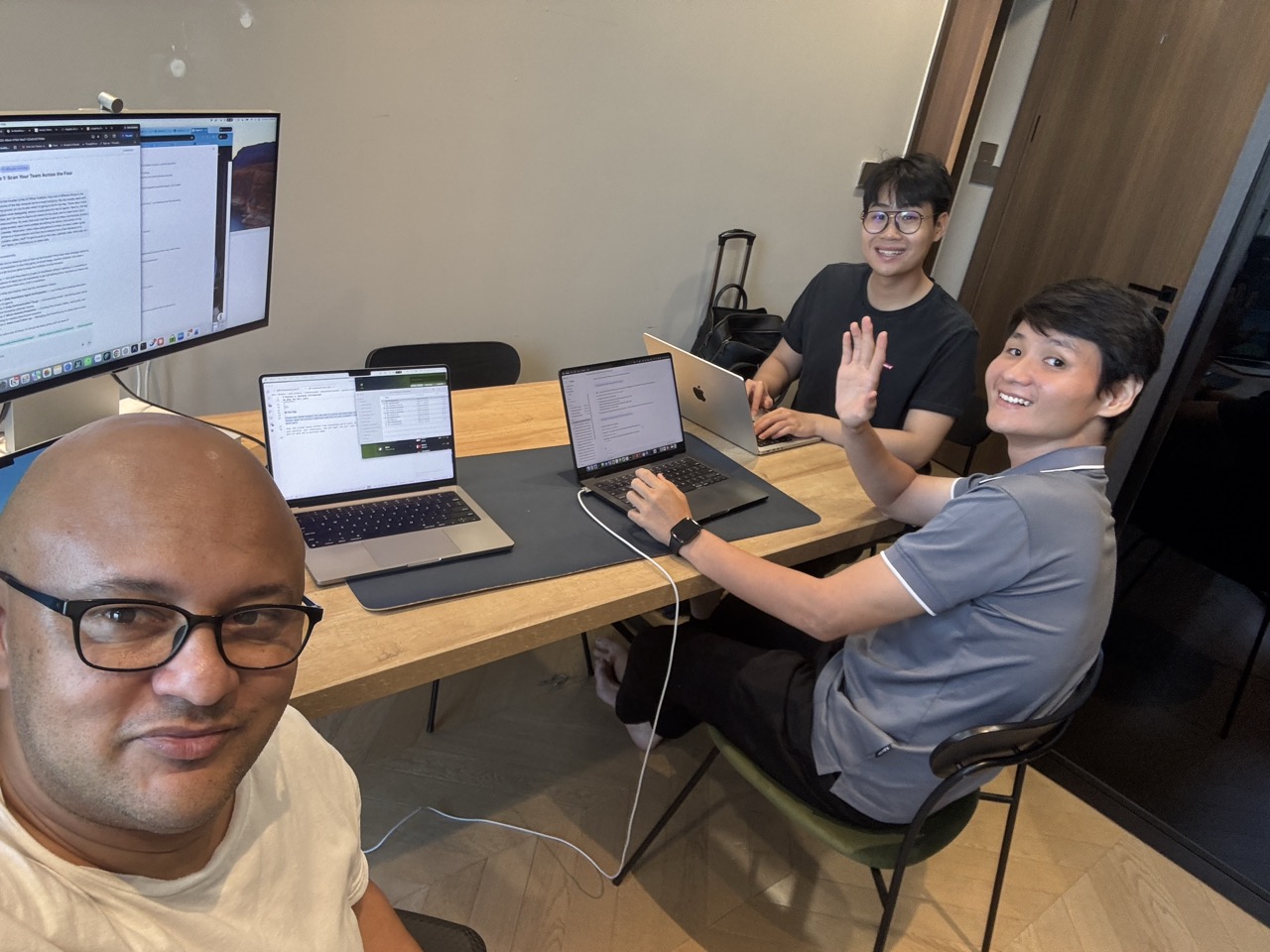 Dave with two builders at the desk, the system on screen